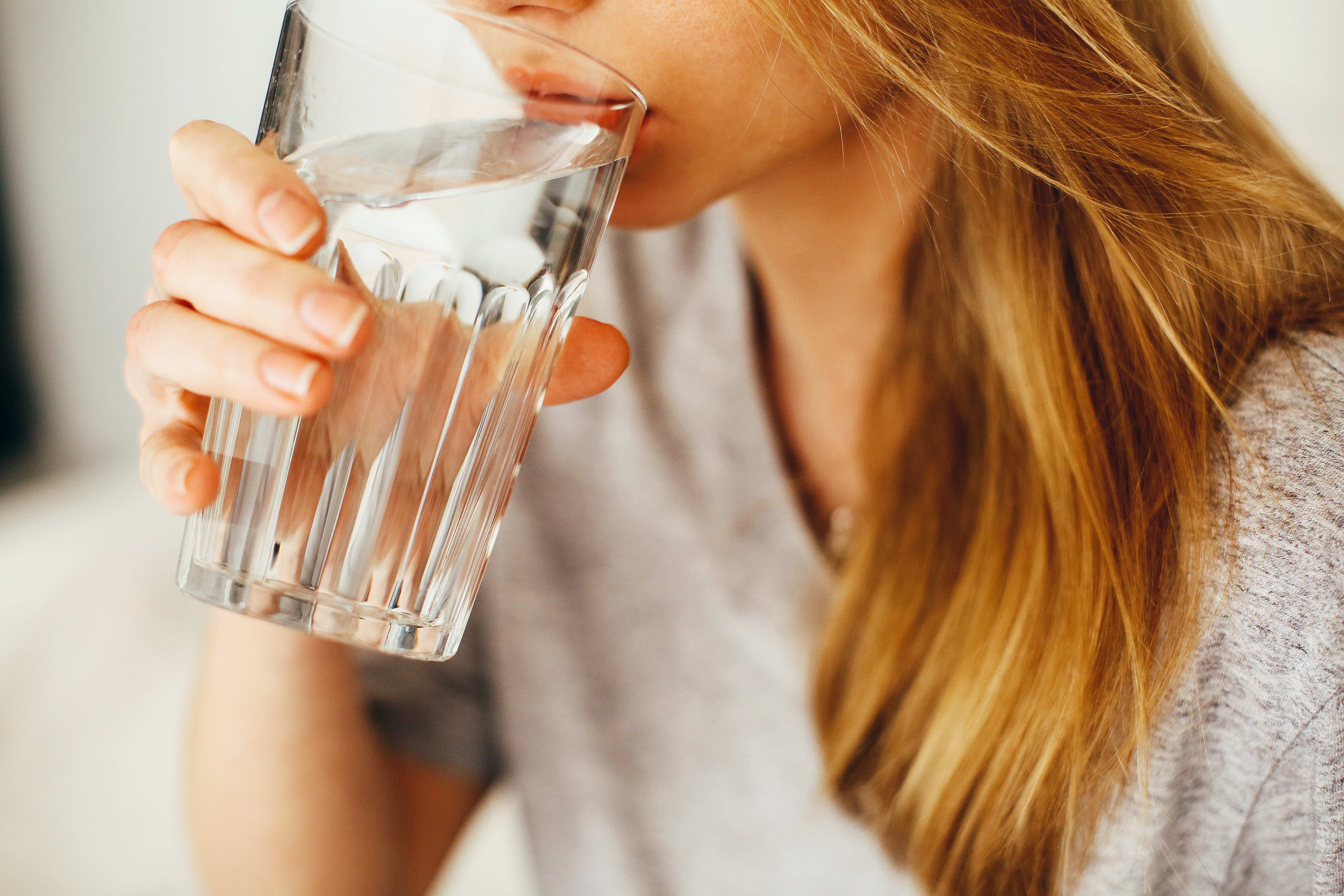 woman drinking water on a glass